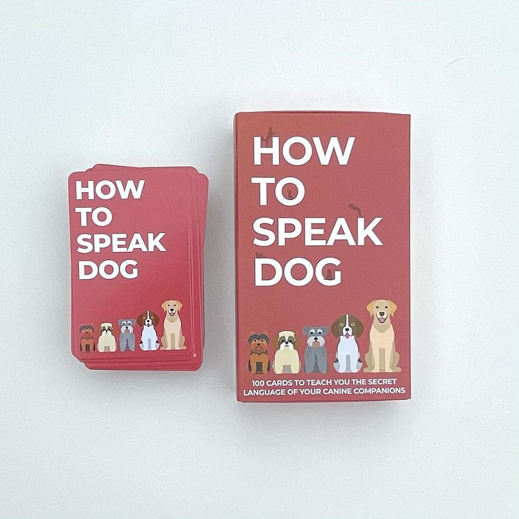 A boxed card deck and a stack of matching red cards on a plain white background. The product is titled "HOW TO SPEAK DOG" with illustrated dogs along the bottom and small dog silhouettes scattered across the cover.