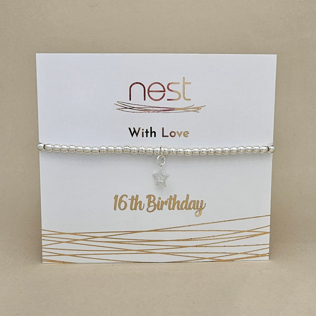 A silver beaded bracelet with a small star charm, displayed on a white card that reads 'nest With Love 16th Birthday' against a beige background.