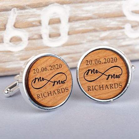 A pair of round silver cufflinks with engraved light brown wood faces, featuring the wording '20.06.2020' infinity shaped wording 'Mr and Mrs' and the name 'Richardson'