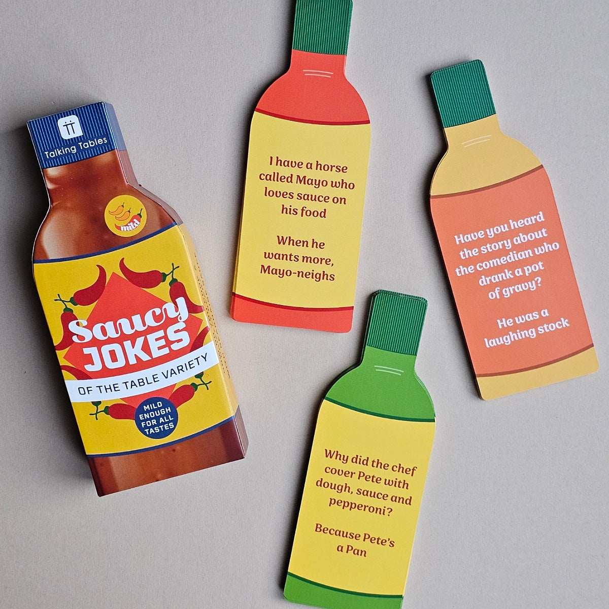Saucy Jokes bottle-shaped cards with humorous text on a gray background