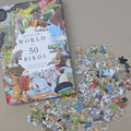 Jigsaw puzzle with bird-themed pieces next to a book titled 'Around the World in 50 Birds' on a beige background