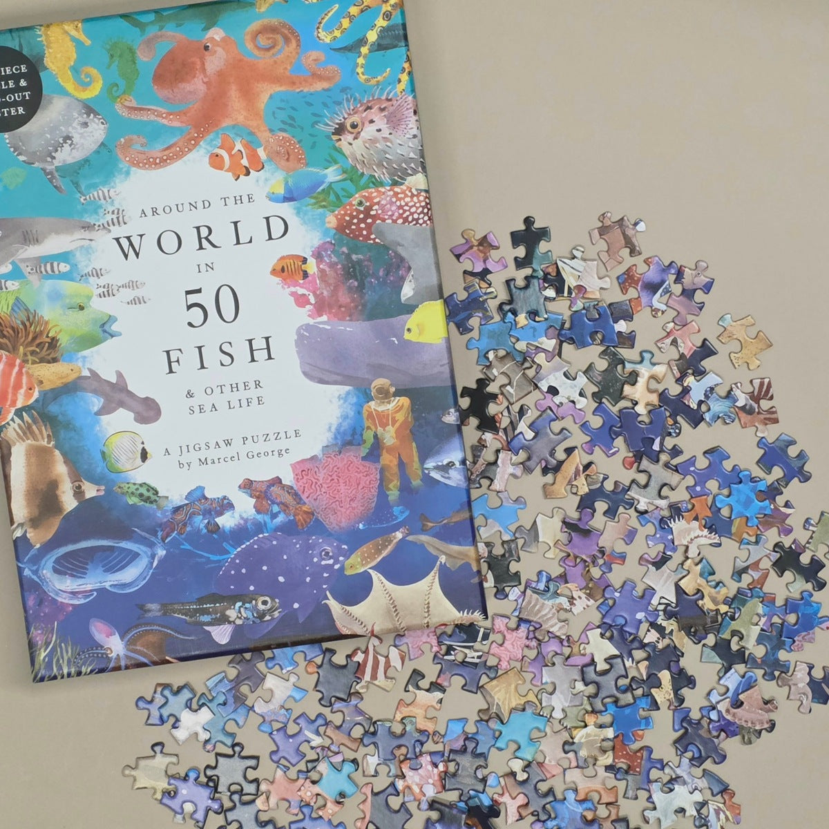 Jigsaw puzzle with 'Around the World in 50 Fish' book on a beige surface