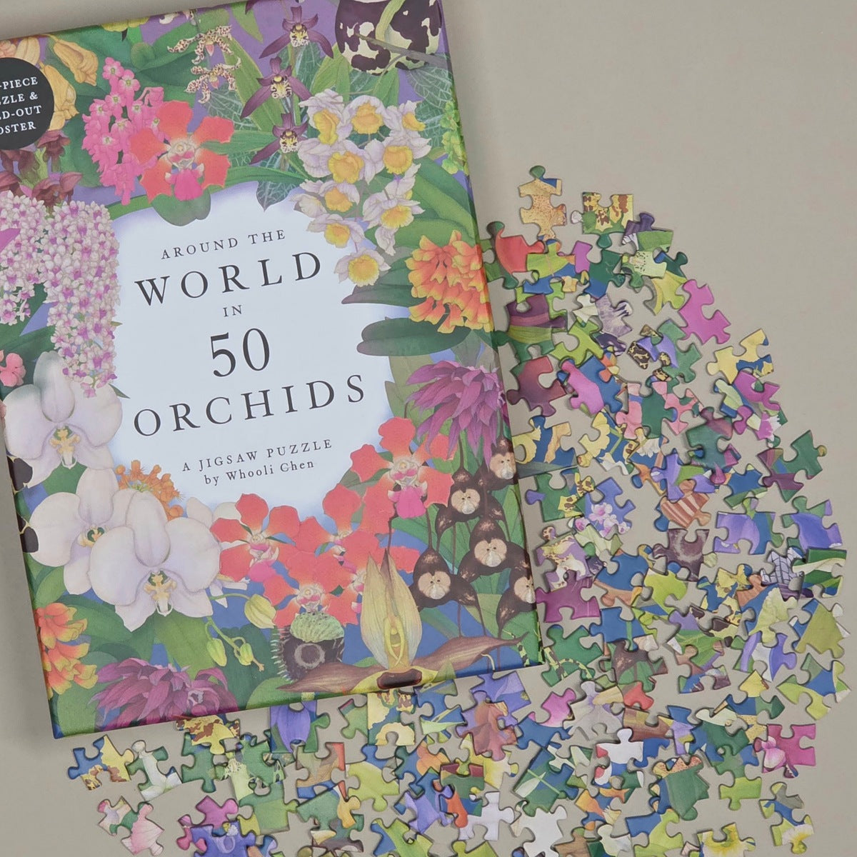 A jigsaw puzzle titled "Around the World in 50 Orchids" by Wooll Chen, shown with many loose puzzle pieces scattered on a light beige surface. The cover features a colorful floral illustration with orchids and other blossoms.