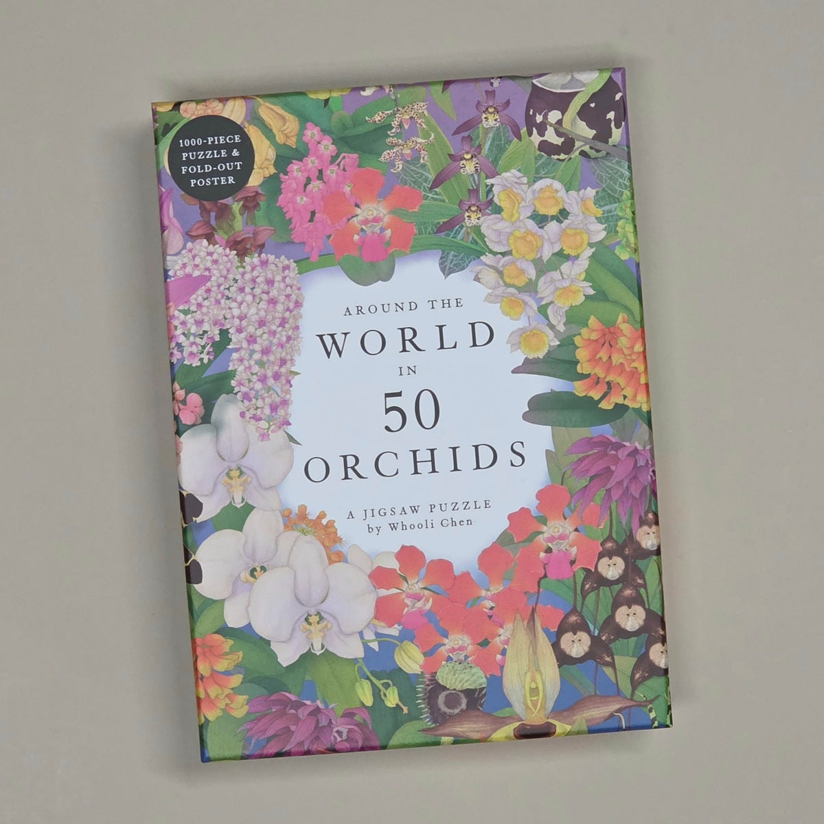 A boxed puzzle product titled "Around the World in 50 Orchids" by Wei-Li Chen, shown standing against a plain light gray wall. The box is covered in colorful orchid and floral illustrations with a white title panel in the center and a small circular badge reading "150-piece puzzle & fold-out poster.