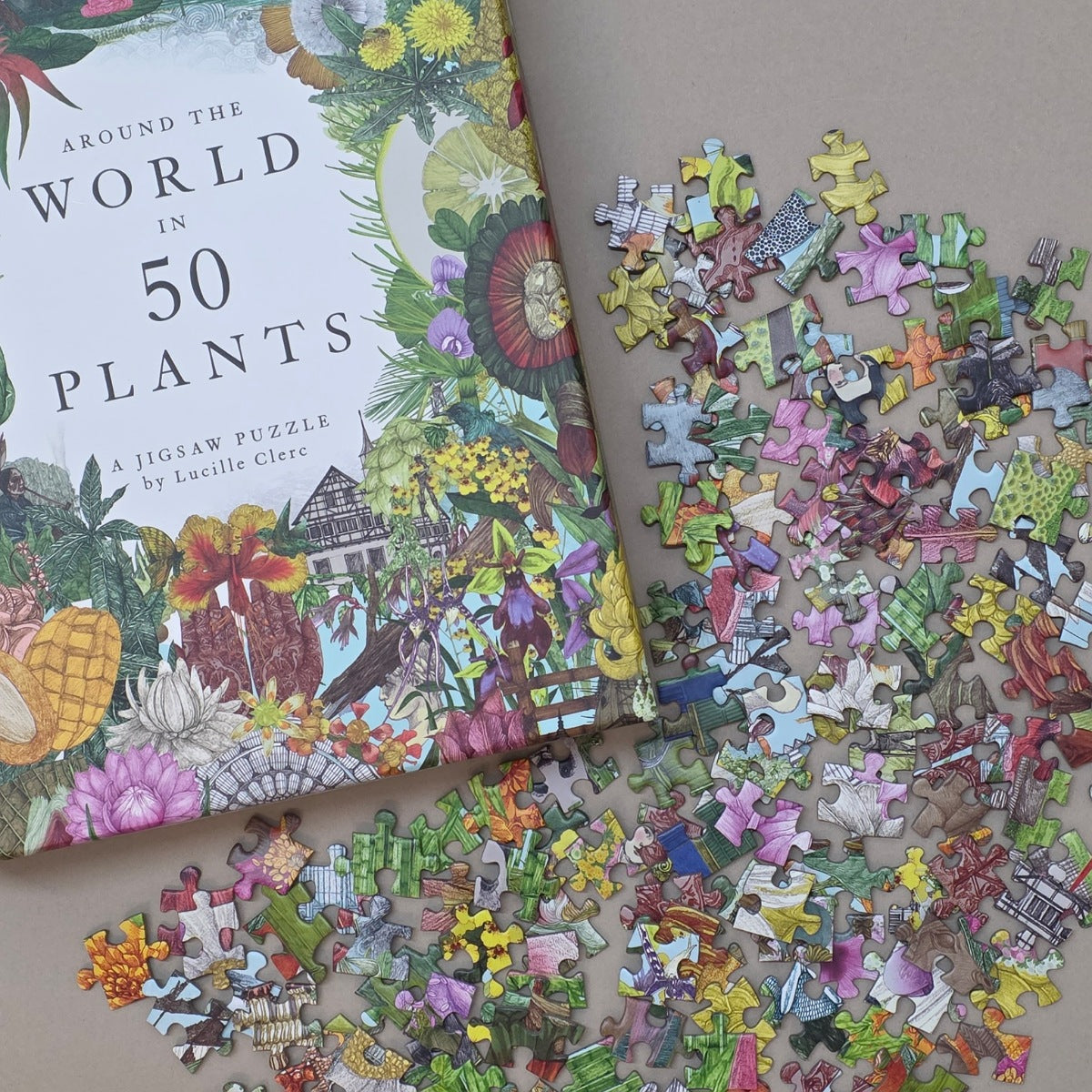 Jigsaw puzzle with 'Around the World in 50 Plants' book on a wooden surface