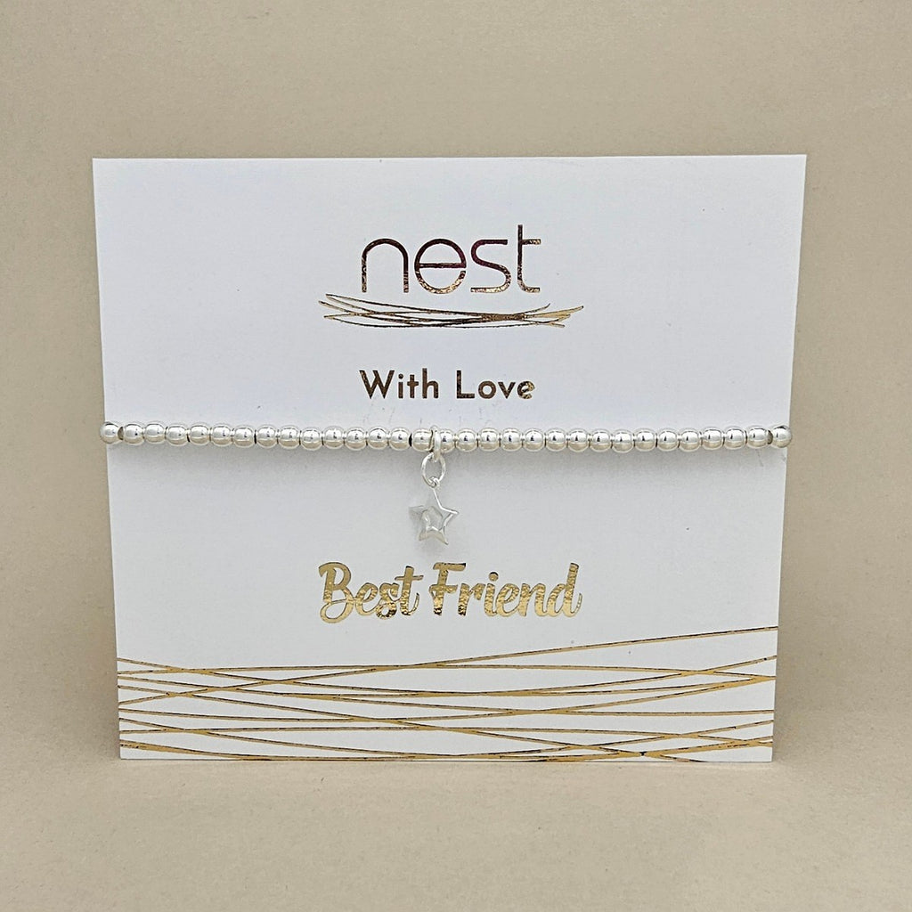 A silver beaded bracelet with a small star charm, presented on a white display card with gold foil accents and the text 'nest With Love Best Friend'.