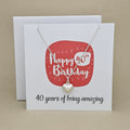A silver heart necklace displayed on a white card with a red rounded square and the text 'Happy 40th Birthday' and ’40 years of being amazing,'
