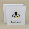 A pair of silver open star shaped earrings are displayed on a white gift card featuring a bee illustration and the phrase 'Always bee yourself'.