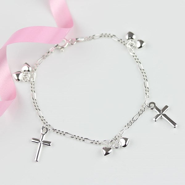 A silver-tone chain bracelet with multiple dangling charms, including three crosses, a heart, and heart charms, displayed on a light gray background with a pink ribbon.