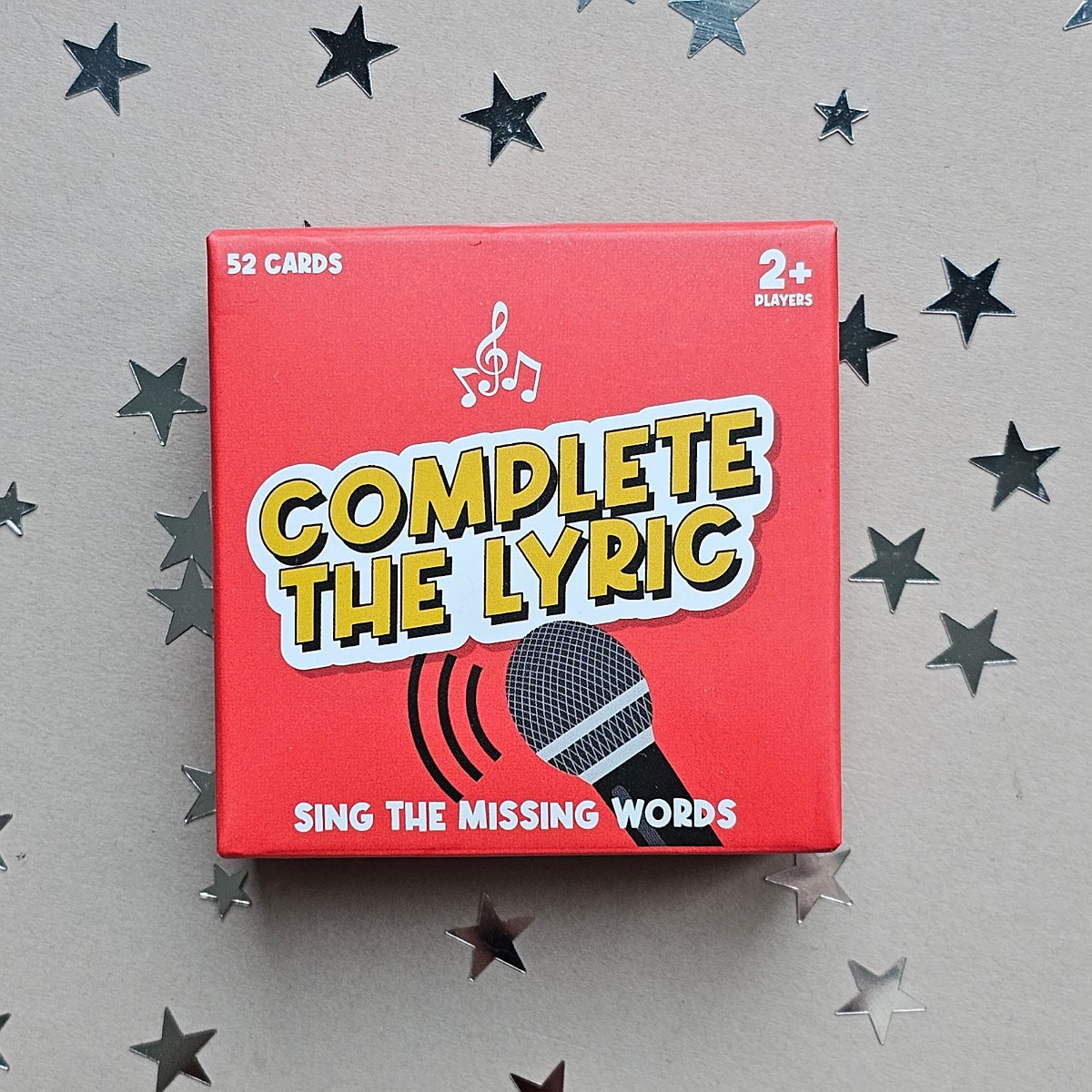Card game box titled 'Complete the Lyric' with a microphone graphic on a star-patterned background.