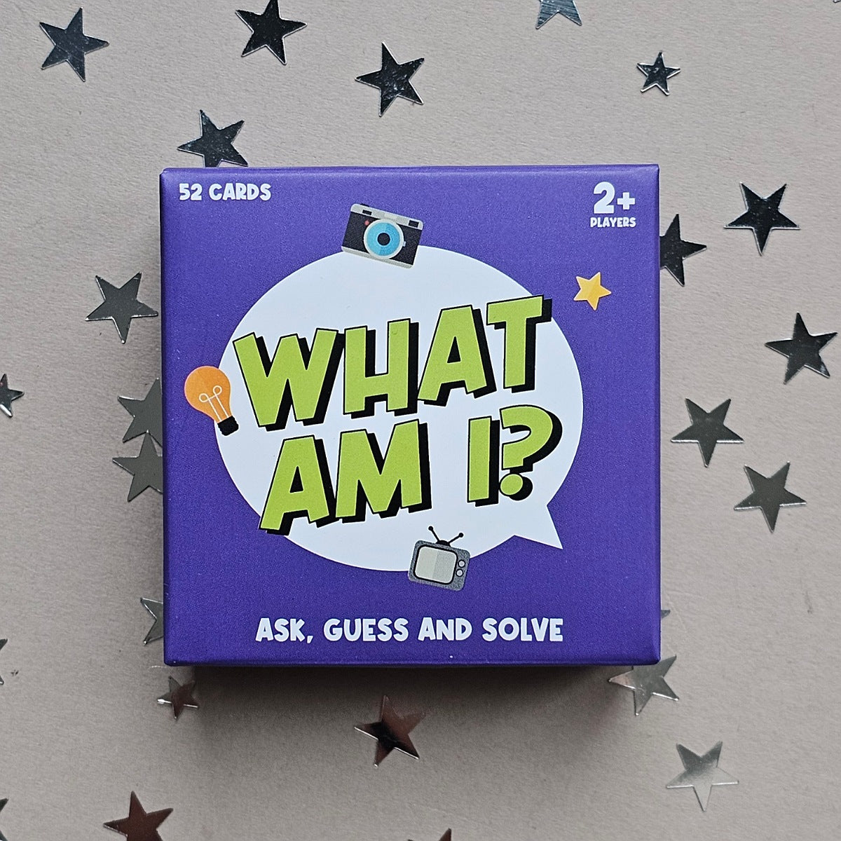 Card game box titled 'What Am I?' on a gray background with star decorations