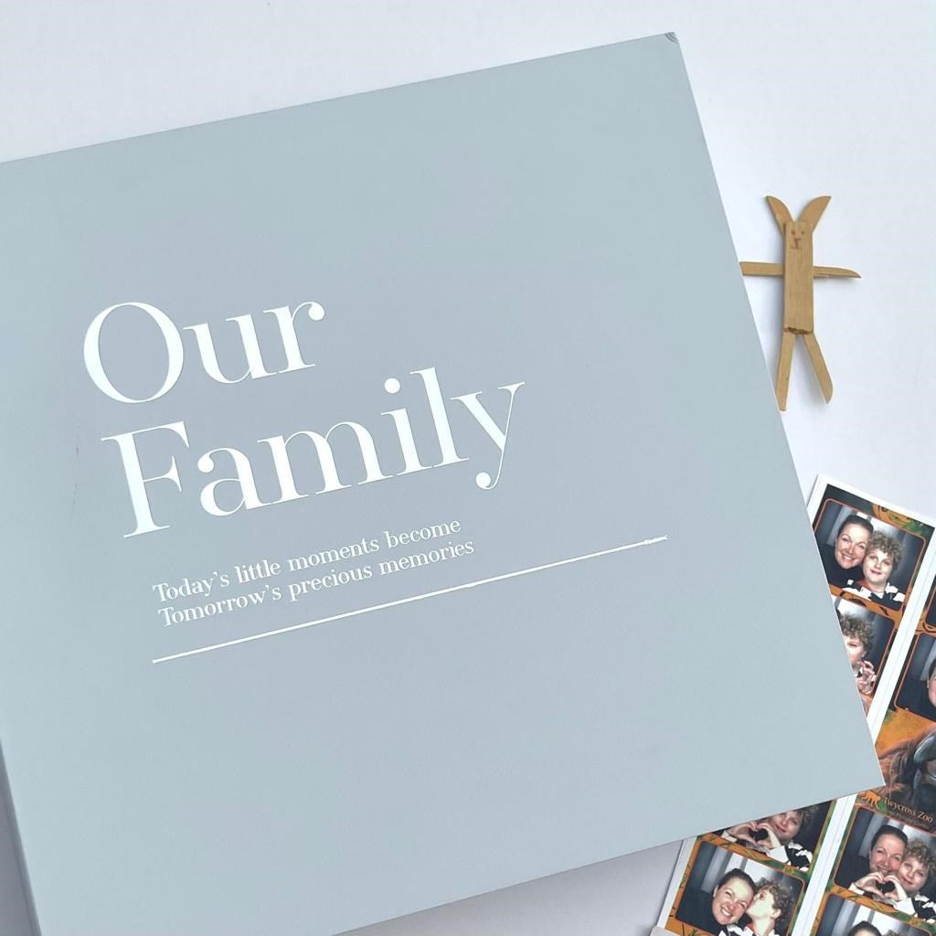 Family photo album box keepsake with 'Our Family' silver foil text and family photos on a light background