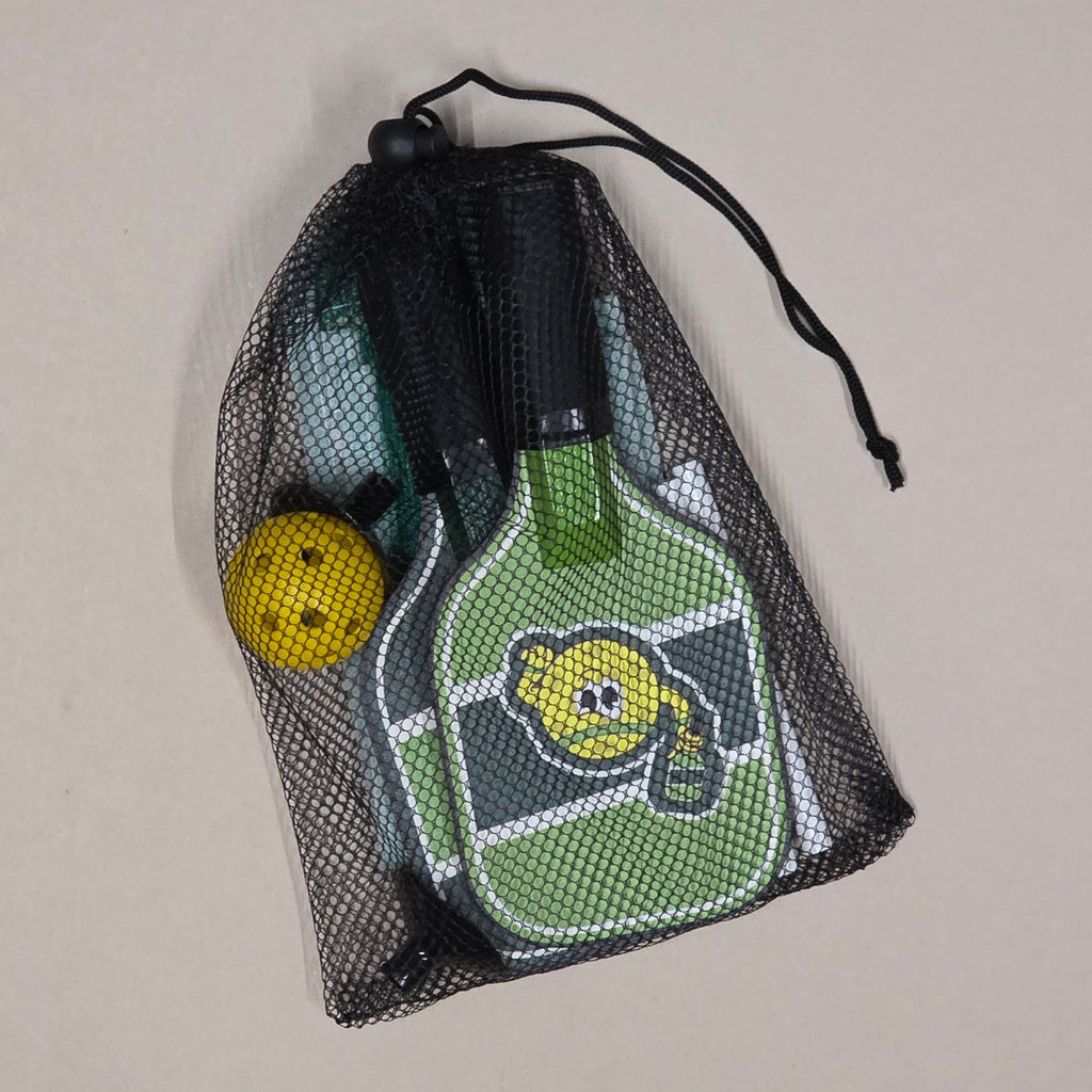 Green pickleball paddle with yellow ball in a black mesh bag on a beige background