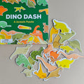 Dino Dash dinosaur puzzle with pieces scattered on a neutral background