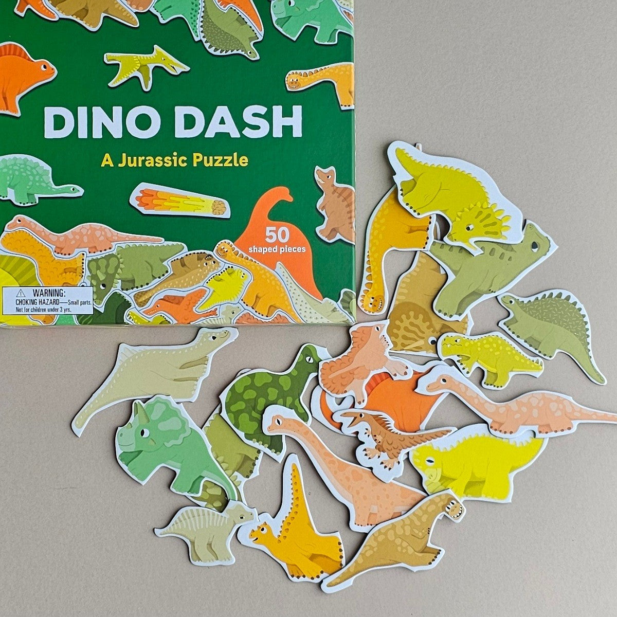Dino Dash dinosaur puzzle with pieces scattered on a neutral background