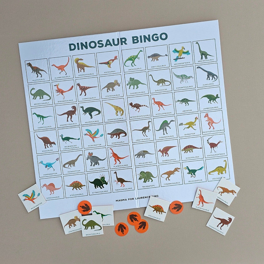 Dinosaur bingo game set with a large bingo sheet and small cards on a beige background
