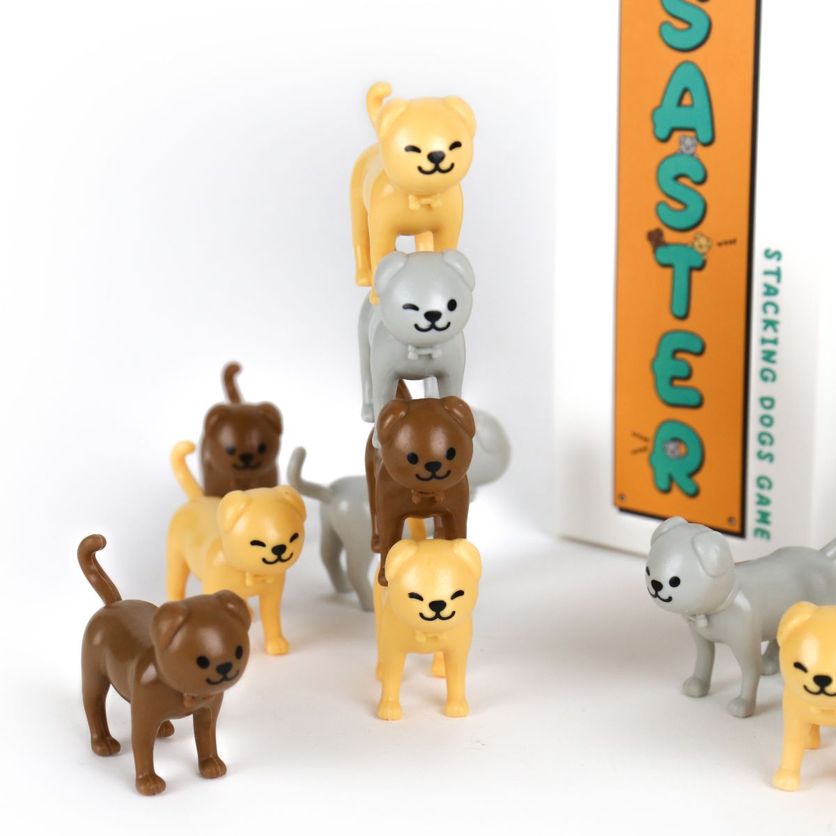 Stacking dogs game with colorful dog figures and a vertical board displaying 'Saster'.