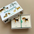 Dogs & Puppies Memory Game set with a white box featuring dog illustrations, two cards showing Beagle dogs, photographed on a beige background.