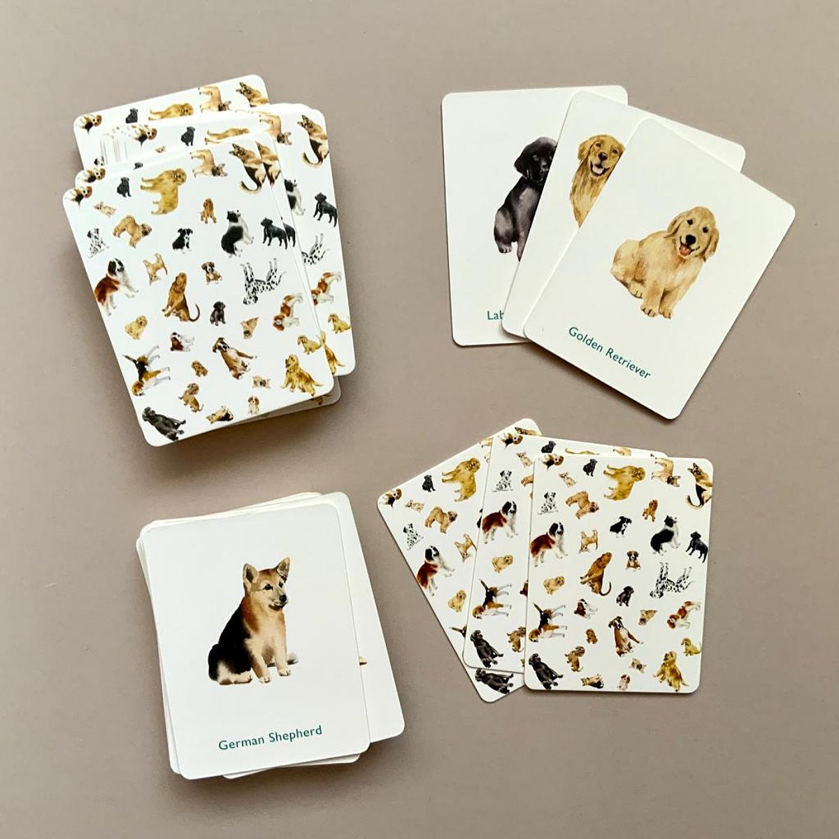 Set of playing cards with dog illustrations on a beige background