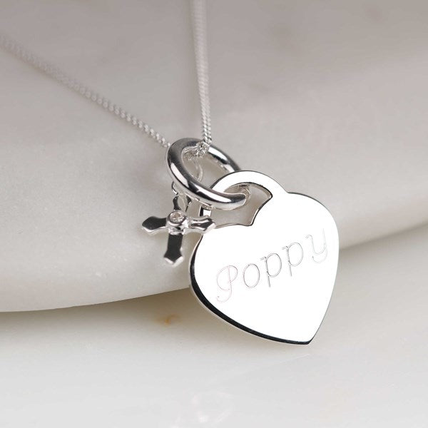Silver necklace with a heart-shaped pendant engraved with 'Poppy' on a light background