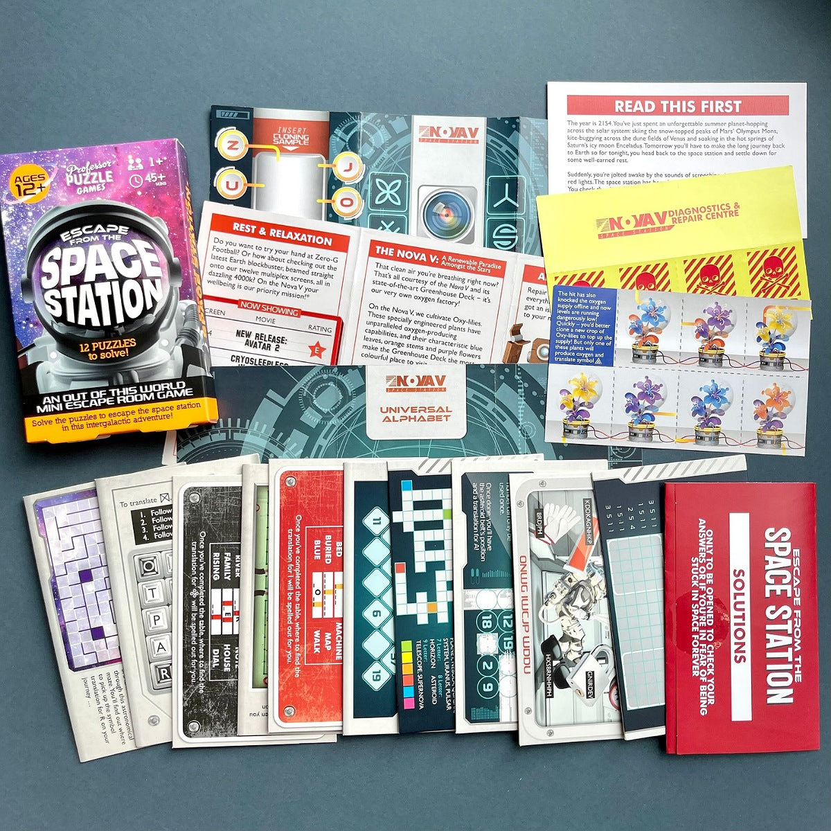 Escape from the Space Station puzzle game box with various information sheets on a blue background
