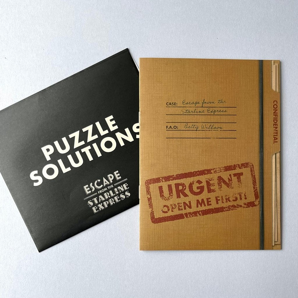 Black book titled 'Puzzle Solutions' and a brown notebook with 'URGENT OPEN ME FIRST!' stamp on a light grey background
