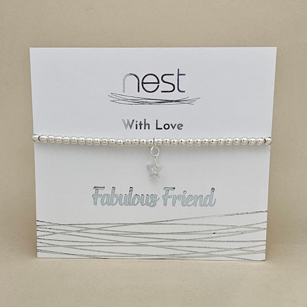 A silver beaded bracelet with a dangling star charm, displayed on a white card that reads 'nest With Love Fabulous Friend' against a beige background.