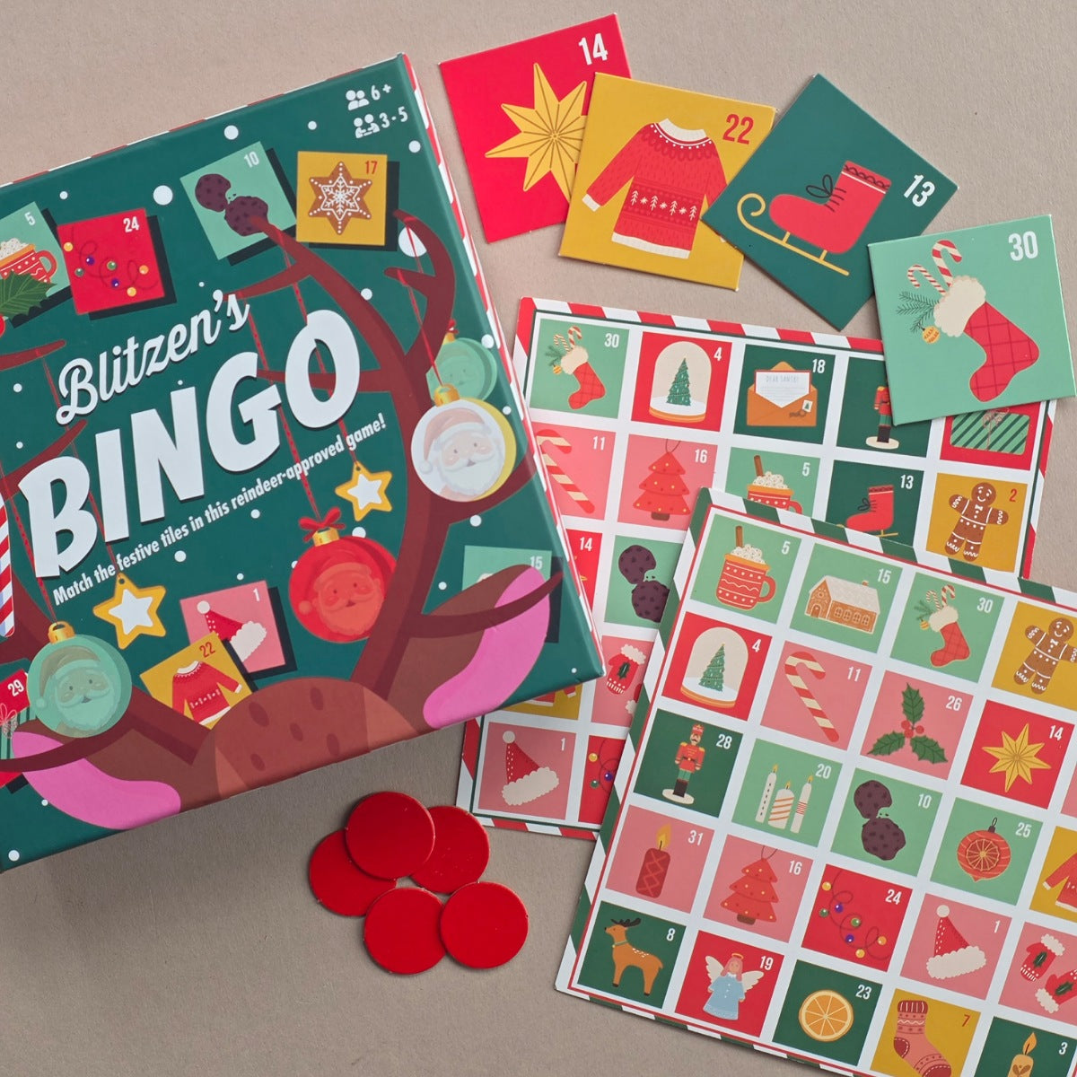 Blitzen's BINGO game with a decorated green box, colourful numbered cards, and bingo grids on a neutral surface.