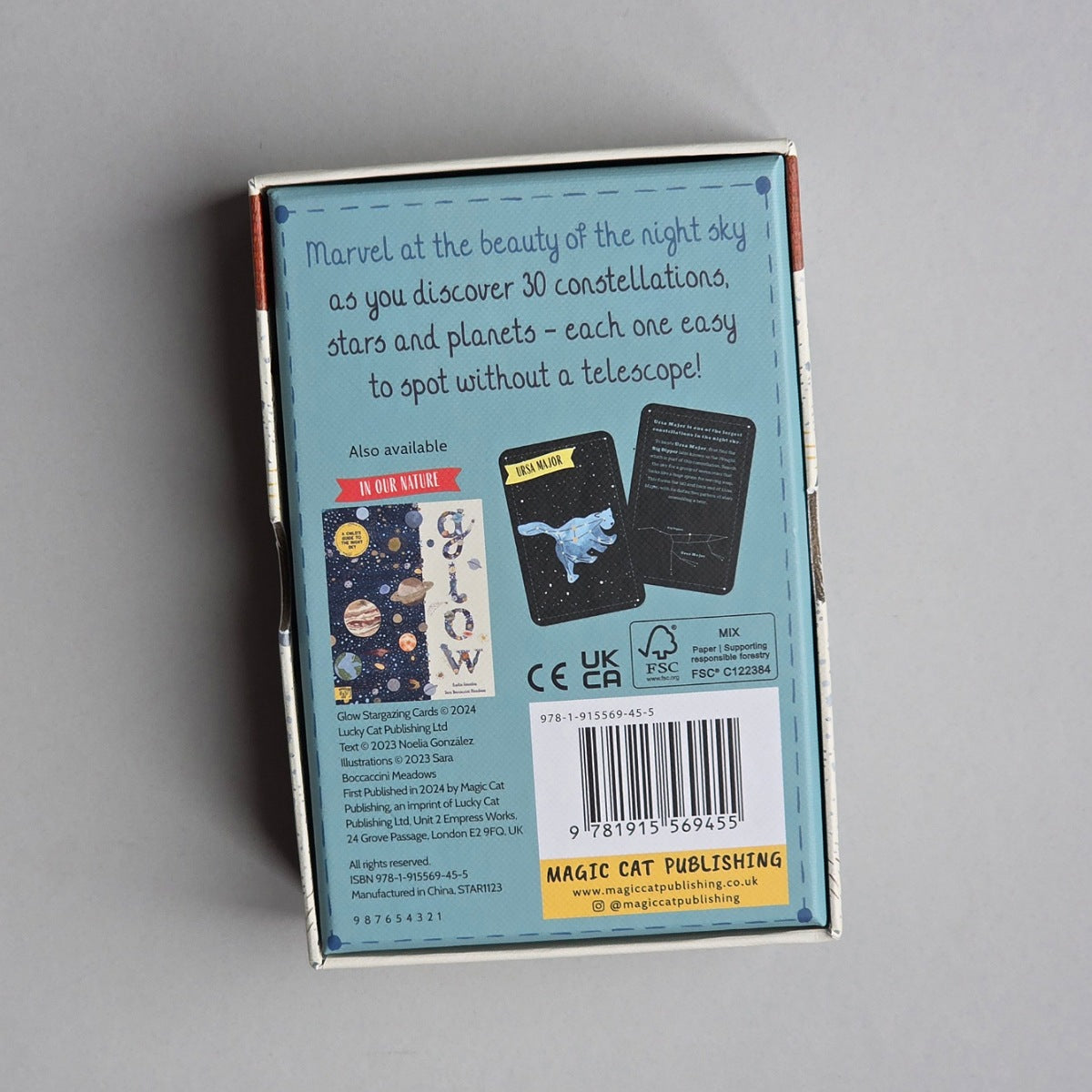 The back of the 'Glow' book box, showing the product's packaging with a light blue background, barcode, and product details on a neutral grey surface.