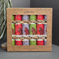 A boxed set of Gruffalo-themed party crackers from Gisela Graham London, displayed in a brown cardboard gift box with printed illustrations. The crackers are wrapped in red, green, and lavender paper featuring the Gruffalo character and festive designs, tied with thin twine.