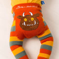 A close-up of a baby's bottom wearing a colorful striped diaper cover with a brown monster face applique and 'The Gruffalo x Blade & Rose' text on the front.