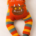 A baby's footed sleeper with orange and yellow stripes on the legs and a large brown monster face applique on the belly. The top is orange with white text reading 'The CRUFFALO x Blade & Rose'.