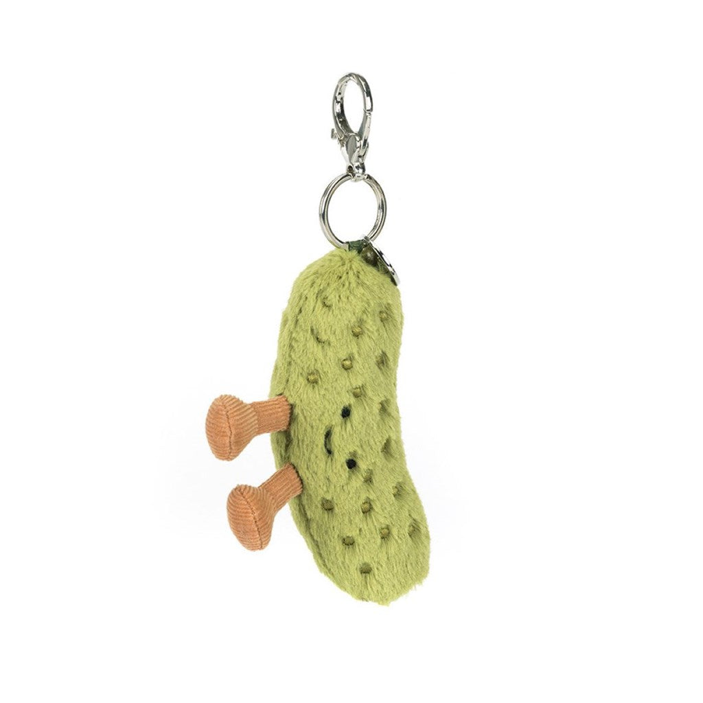 Green textured pickle with brown legs attached to a keychain on a white background