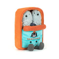 A plush toy shaped like a small orange and turquoise sardine can, with two grey sardine figures peeking out from the top and embroidered text reading 'SARDINAS' on the front.