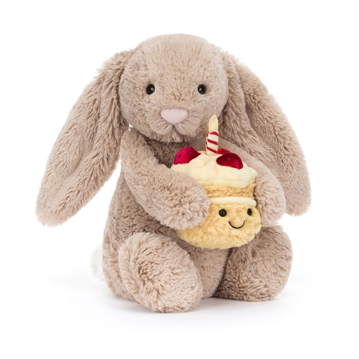 A plush toy bunny in warm taupe holding a small yellow cupcake character with a smiling face, red cherries, and a striped candle, photographed on a clean white background.