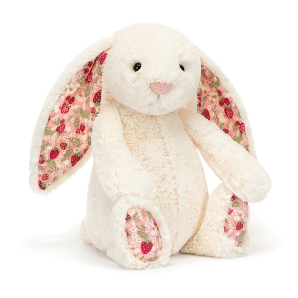 Plush cream bunny toy with strawberry and floral pattern ears on a white background