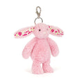Pink plush bunny keychain with floral patterns on a white background