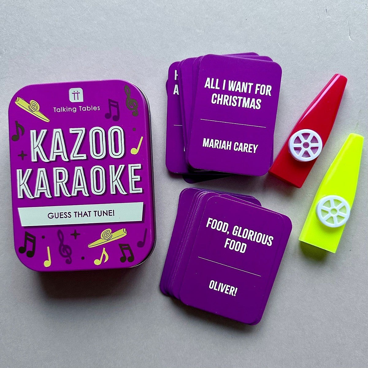 Kazoo Karaoke game set with purple cards and kazoo on a grey background