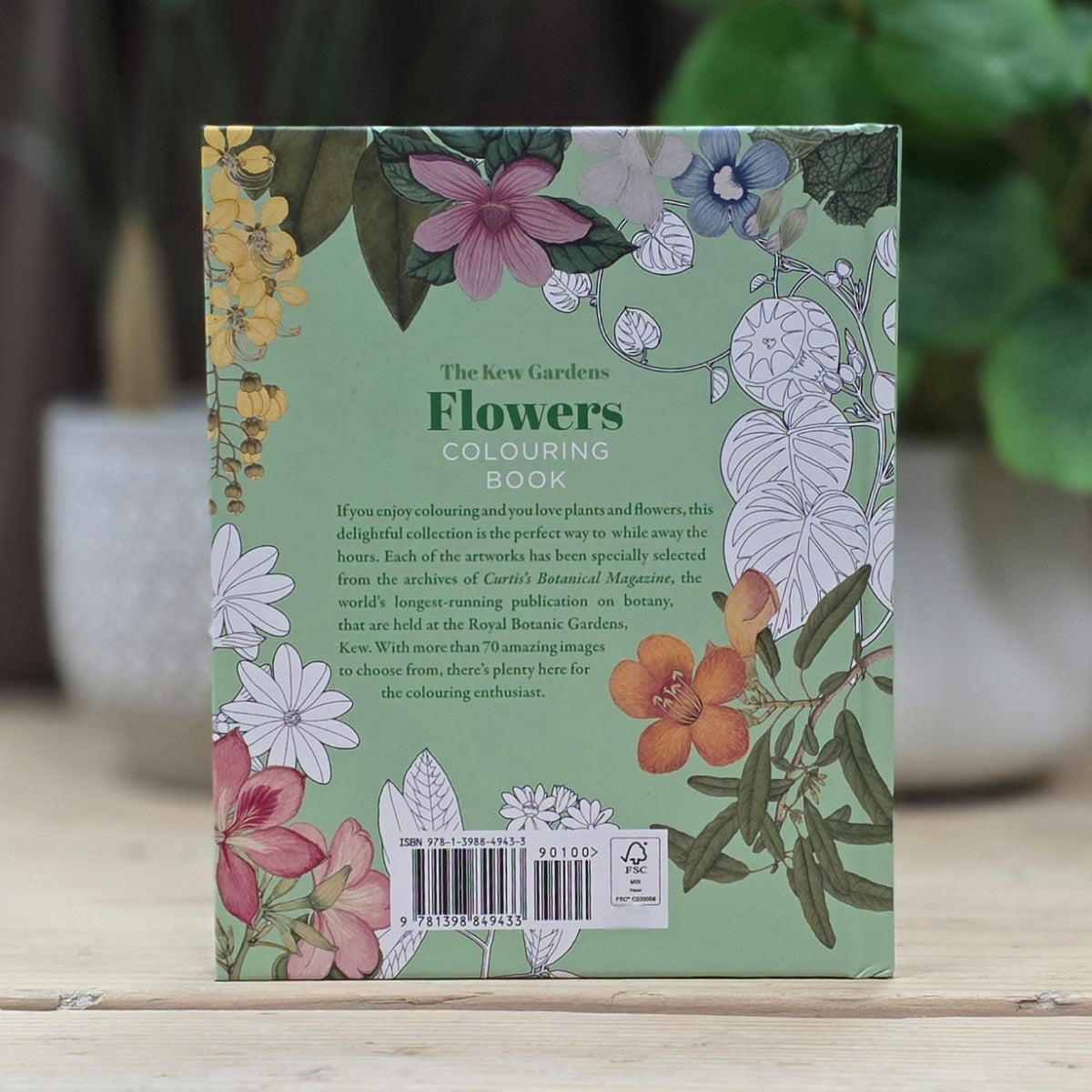 Flowers coloring book with floral illustrations on a wooden surface