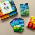 Colorful LEGO-themed playing cards with packaging on a beige surface