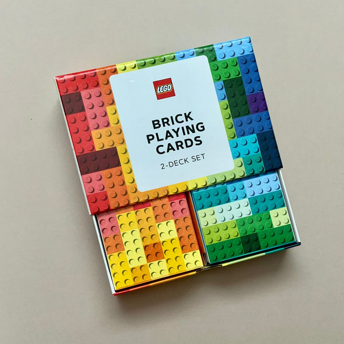LEGO Brick Playing Cards 2-Deck Set in its original packaging, featuring a colorful grid of building brick studs on the box cover and a white label with the red LEGO logo.