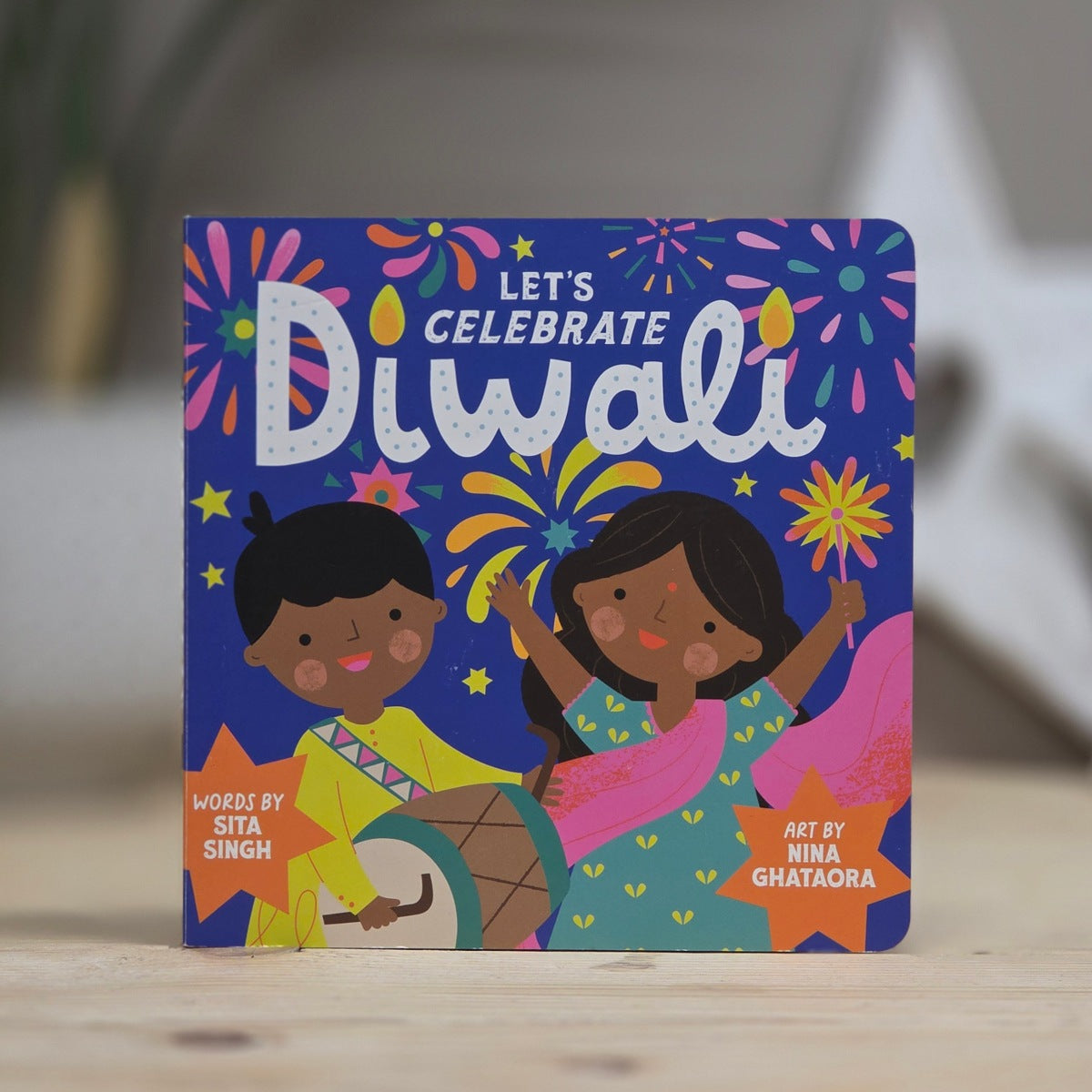 Children's book titled 'Let's Celebrate Diwali' with colorful illustrations of two children on a blue background.