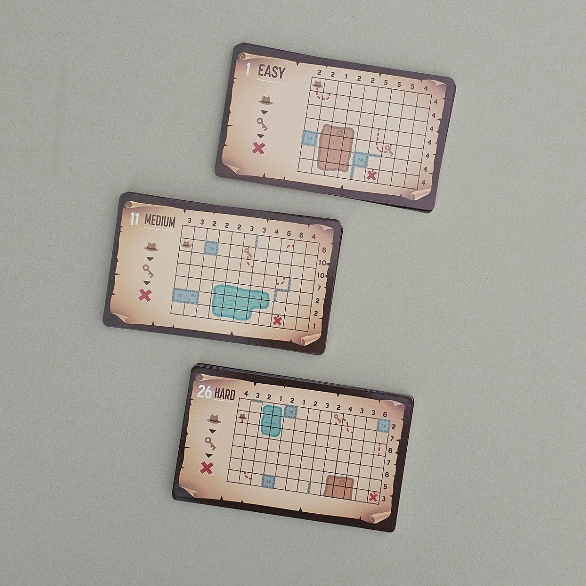 Three grid-based puzzle cards labeled 'Easy', 'Medium', and 'Hard' on a grey background.