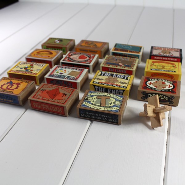 Collection of vintage-style matchbox puzzles on a white surface