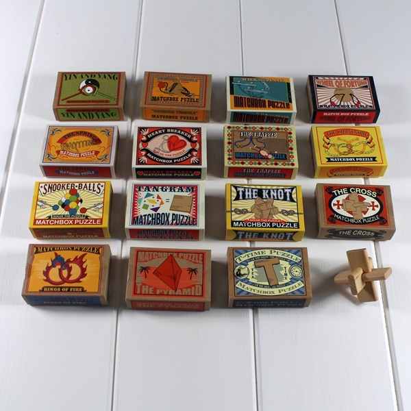 Collection of vintage matchbox puzzles on a white surface