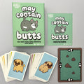 The 'May Contain Butts' card game set by Dr. Squirrel Puzzle Games, showing the mint green box, the instruction booklet, and several cards featuring cartoon pug illustrations on a light grey background.