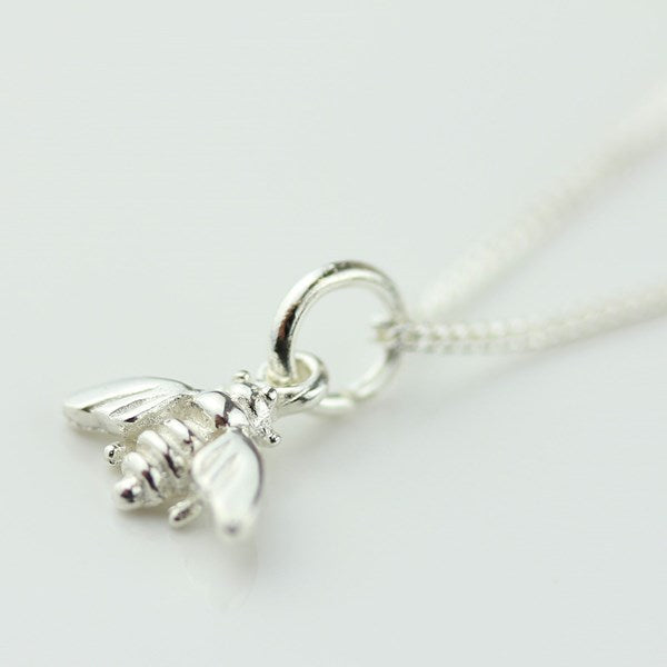 A sterling silver bee pendant necklace on a delicate silver chain, photographed on a clean white background.