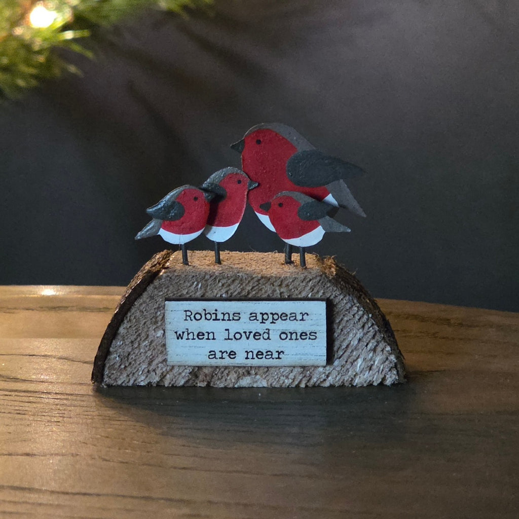 A small wooden block with 4 robins sitting on top with the wording Robins appear when loved one are near
