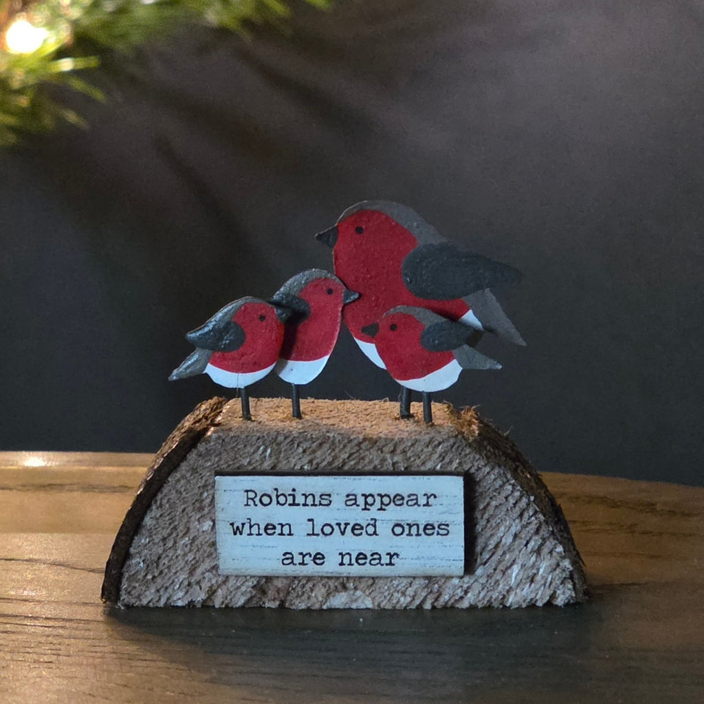A small wooden block with 4 robins sitting on top with the wording Robins appear when loved one are near