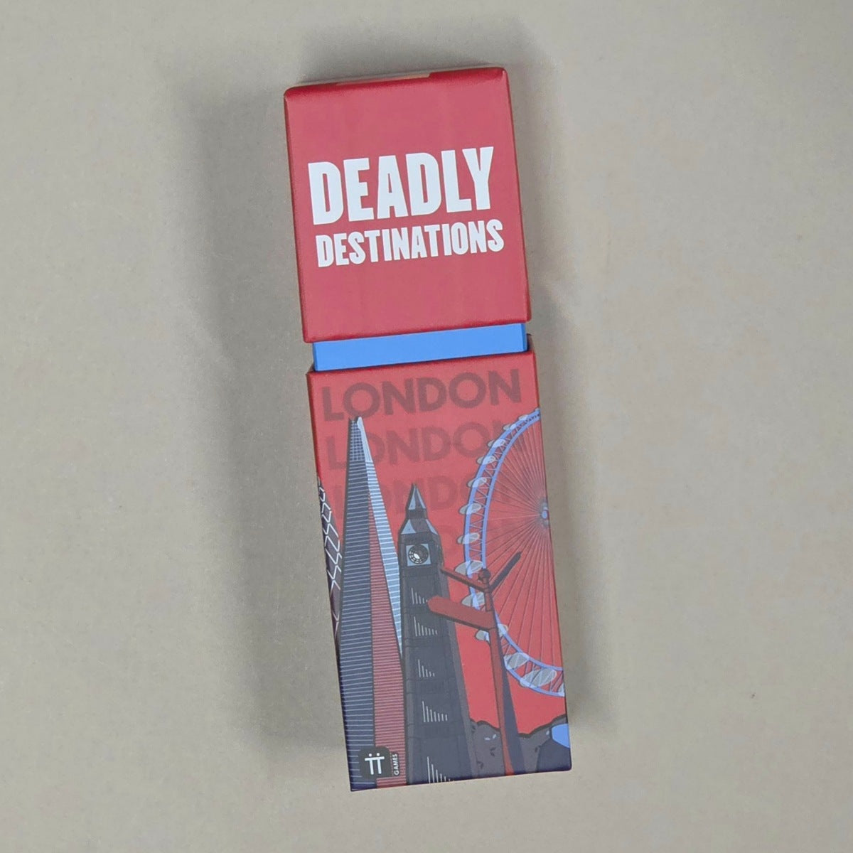 A rectangular red box labeled 'DEADLY DESTINATIONS' with a blue band and a London-themed illustrated lower section, photographed on a plain beige background.